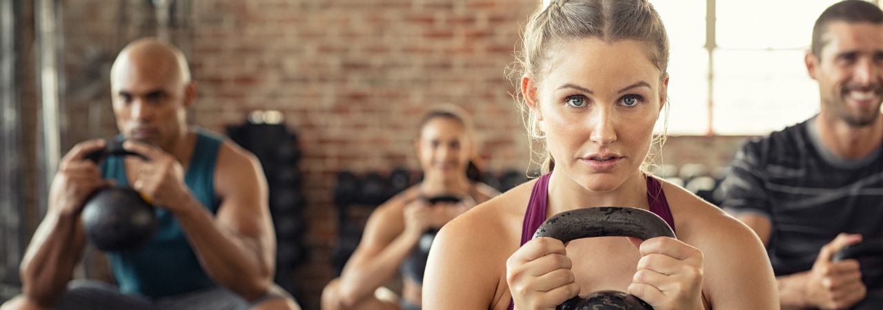 Four people using a kettlebell in a small group trianing class at the Bronson Wellness Center.