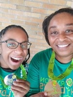 Mom and daughter holding medals from 2020