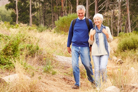 Photo of an elderly couple hiking outdoors.