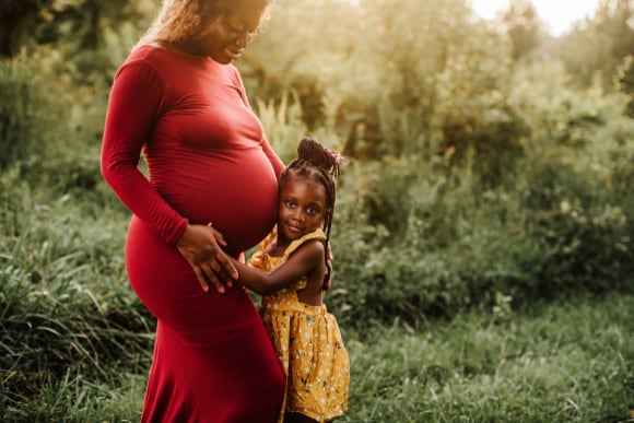 Photo of a pregnant woman and young daughter.