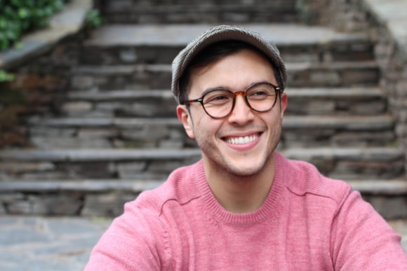 Photo of young man smiling outdoors.