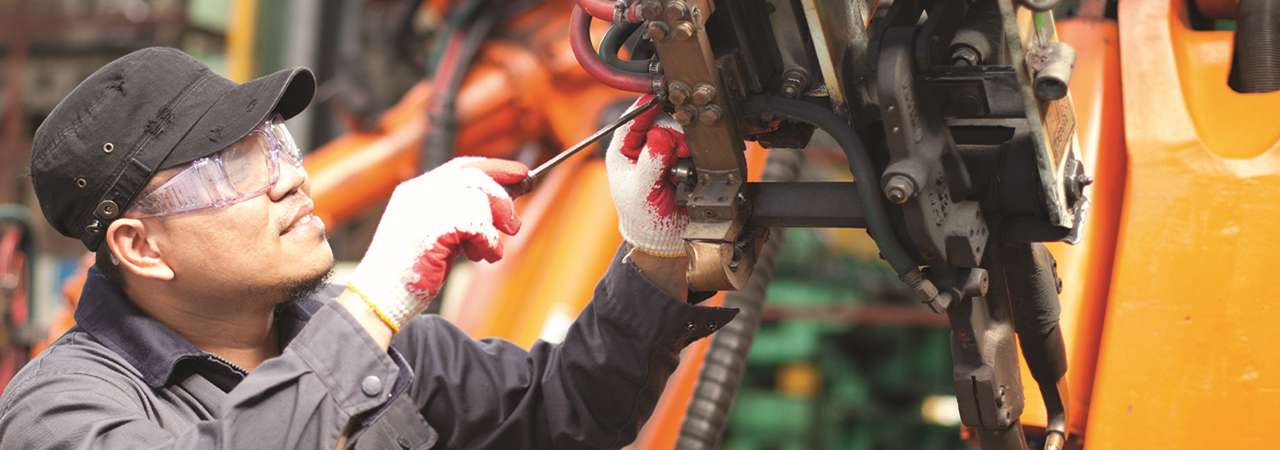 Image of mechanic working on machine.