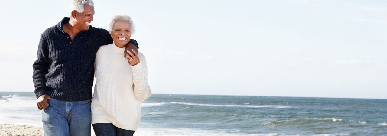 Photo of African American couple walking on beach. 