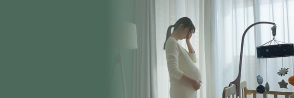 Image of a pregnant person standing in their baby's nursery.