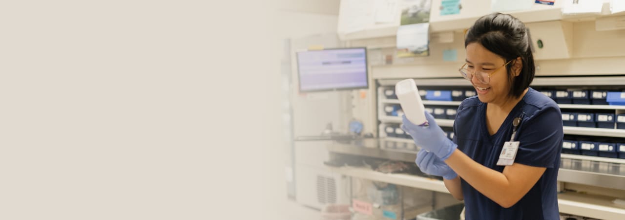 Pharmacy resident working in lab and smiling.