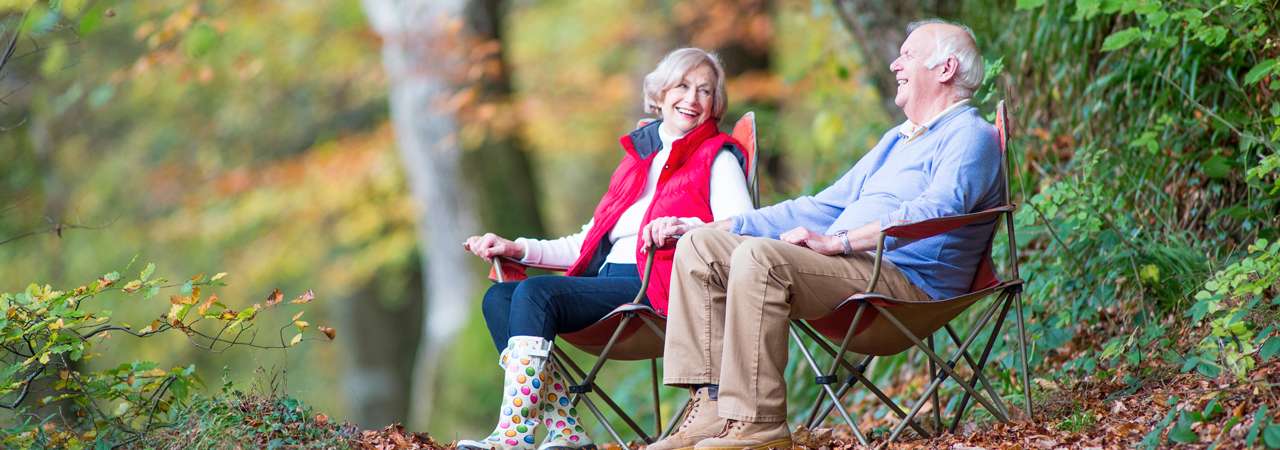 Image of couple relaxing in the woods.