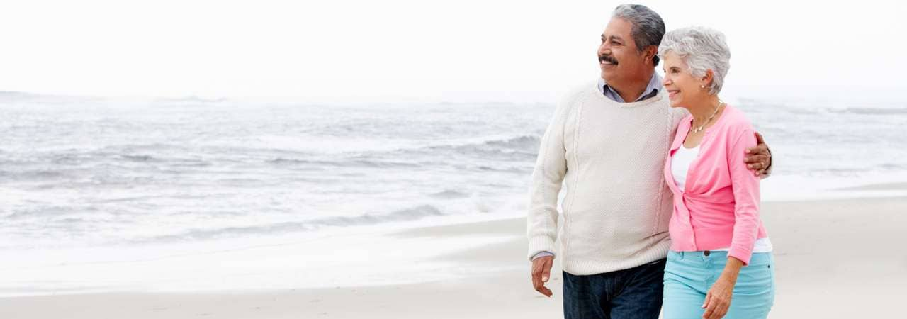 Image of senior couple walking along the beach.