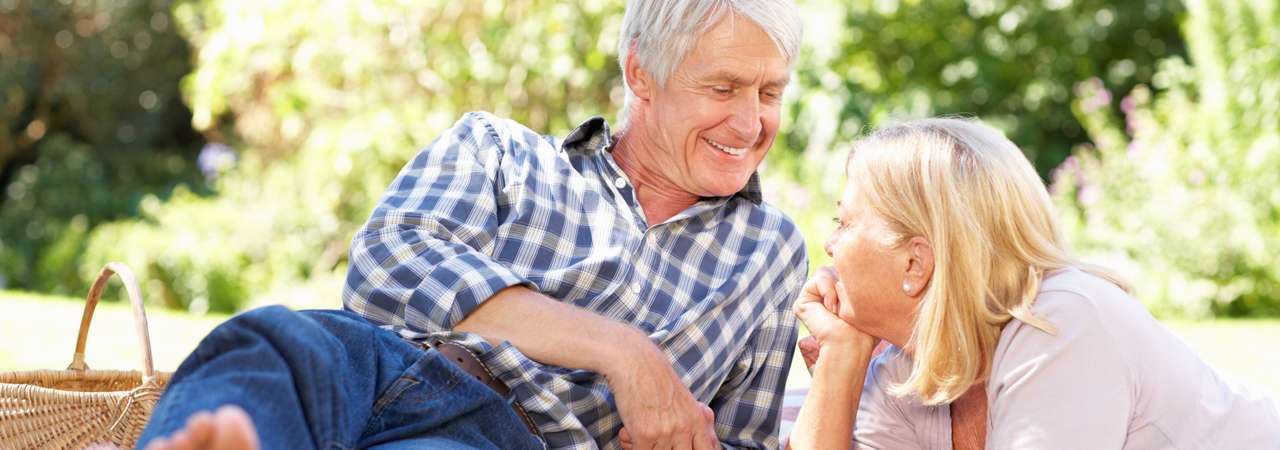 Photo of older couple having a picnic in the park.