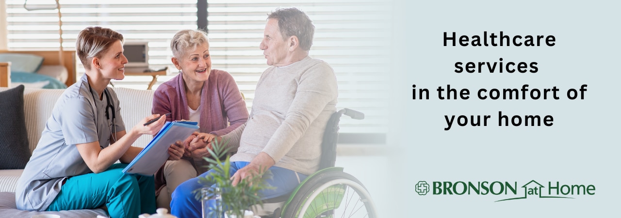 Adult patient in wheelchair and his wife with home healthcare nurse.