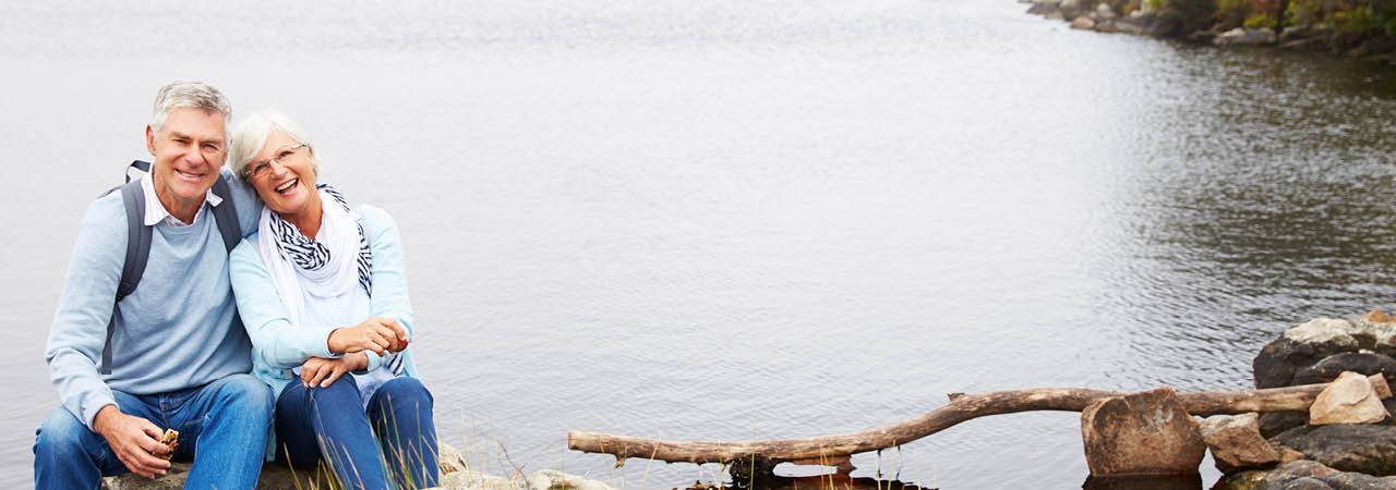 Image of senior couple hiking by a lake.