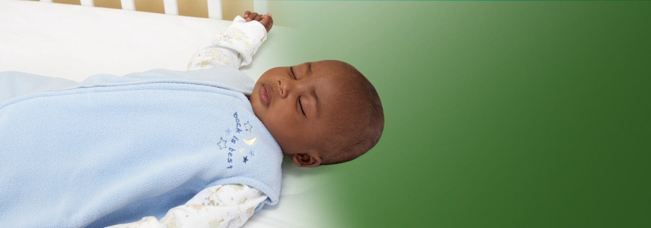 Image of baby sleeping on back in crib.