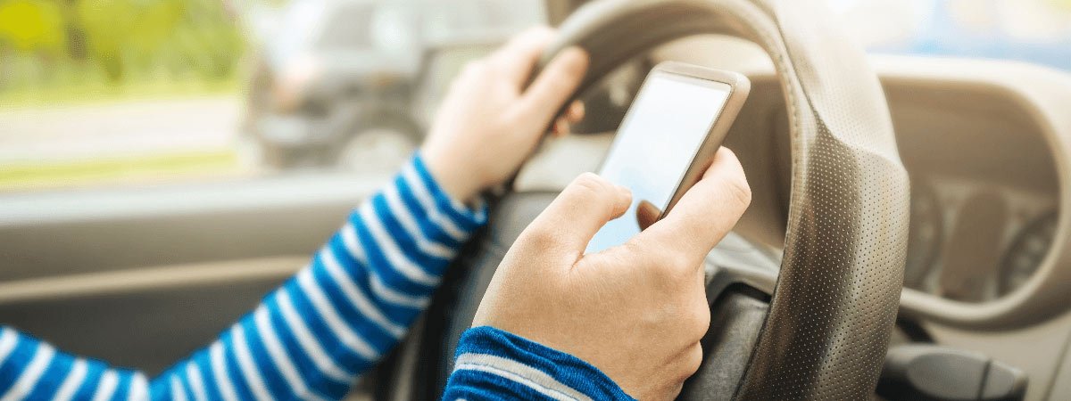 Image of person texting and driving.