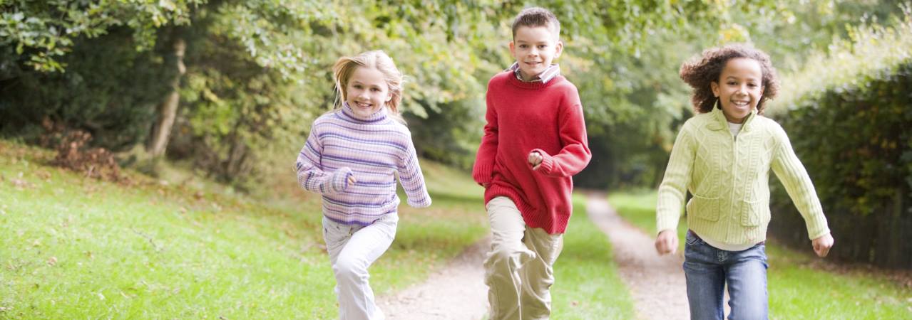 Photo of three children running down path.