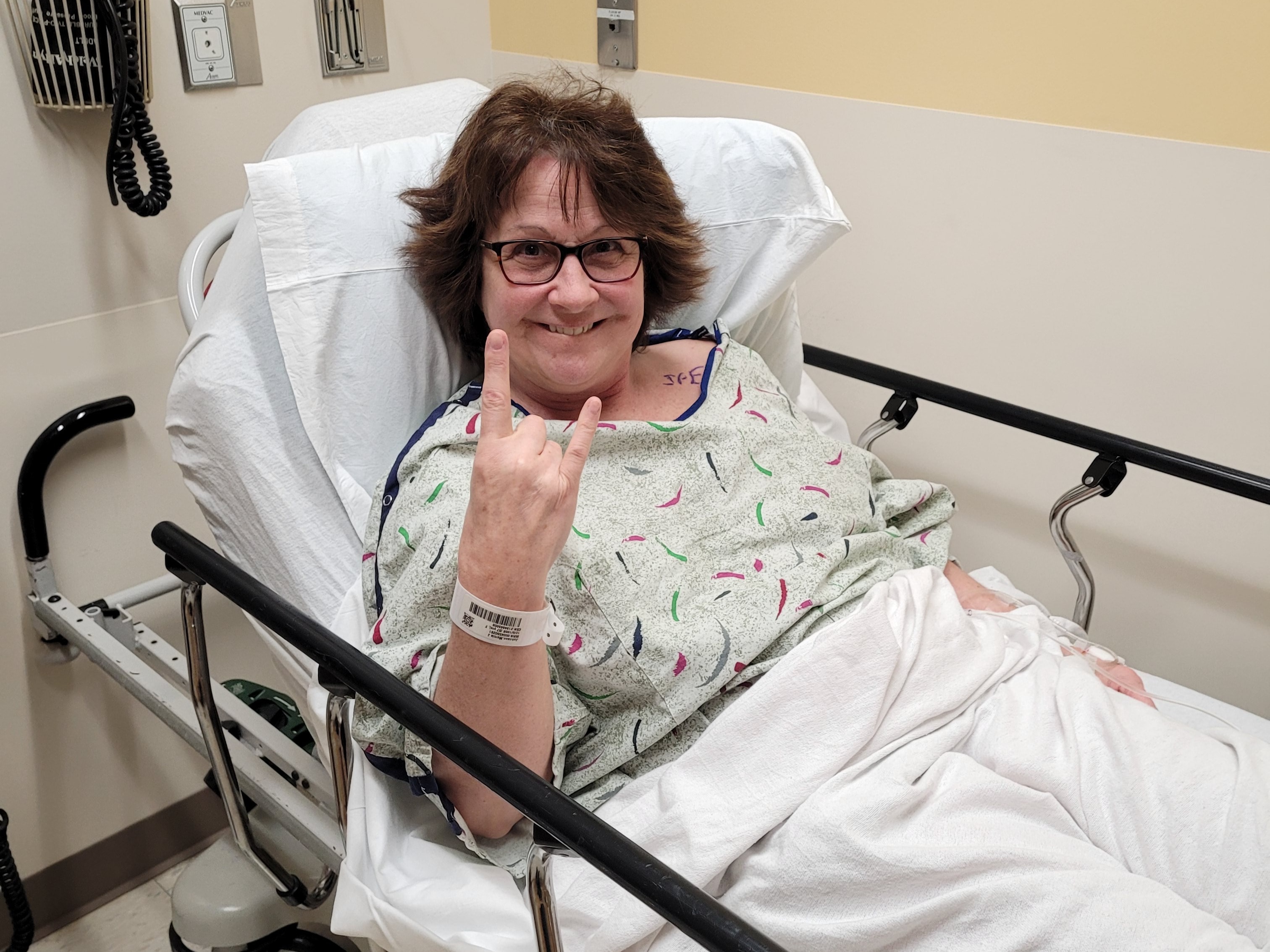 Bronson patient Marcie J. smiles from a hospital bed before surgery.