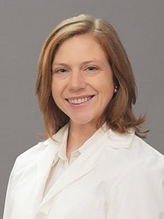 Dr. Codi Sharp smiles for the camera in a white coat.