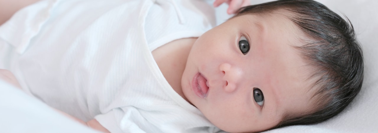 A newborn baby looking at the camera.