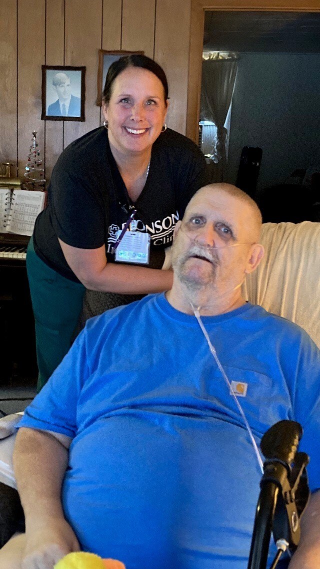 Bronson at Home Heart Failure program patient, Paul, smiles alongside his Bronson caregiver from the comfort of his home. 