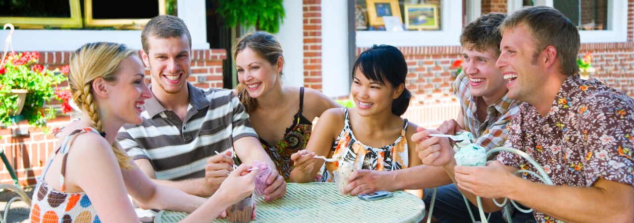 Photo of young adults eating ice cream together.