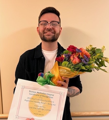 Photo of Cade, a Bronson nurse, smiling with his 2024 Nursing Excellence Award.