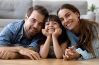 Two adults and a child smile for the camera